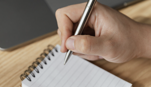 Image of a hand writing notes