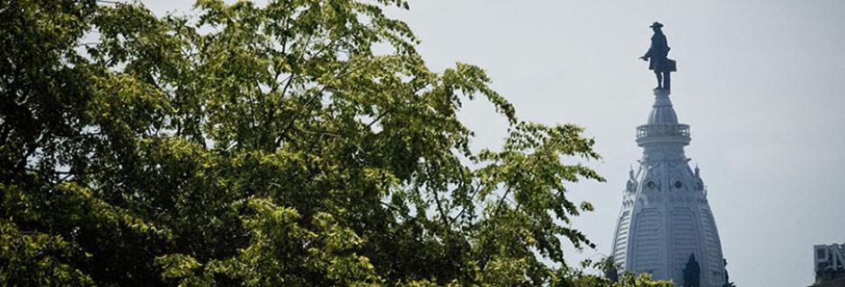 A tree in front of the top of city hall with William Penn from the direction of CCP.