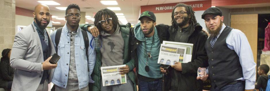 6 students holding up issues of The Vanguard.