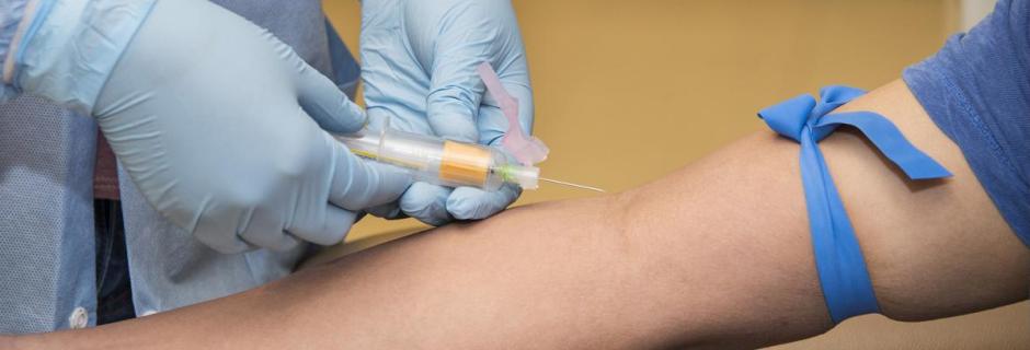 Student putting needle into patient's arm in Phlebotomy Certificate Course.