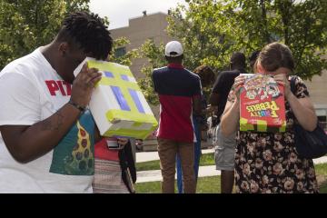 Two people view the eclipse with homemade viewing boxes.