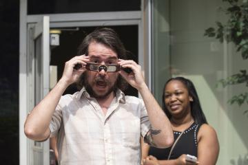 A party goer shows off his eclipse glasses for the camera.