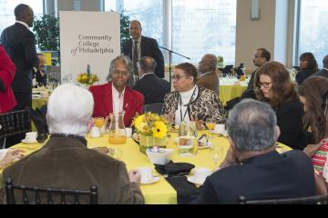 Attendees enjoy breakfast as Dr. Generals and Sulaiman Rahman prepare to speak