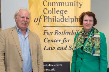 Event holders pose in front of a department sign.