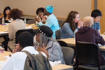 Room shot of groups in discussion.