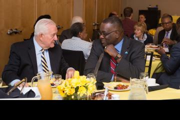 Two attendees chat over breakfast.