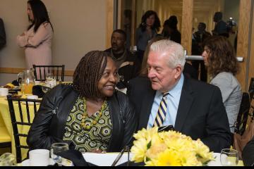 Two attendees chat over breakfast.