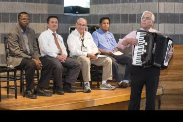 A panel member plays the accordion.