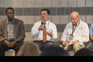 A panel member addresses the crowd.