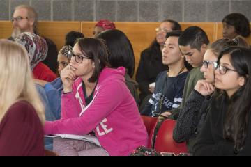 The audience listens.