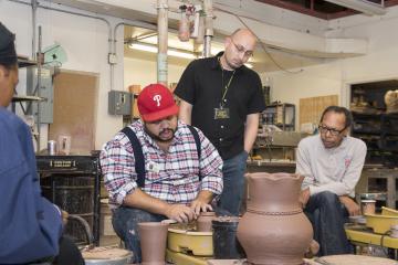 Roberto Lugo describes his technique as he spins a pot on the wheel