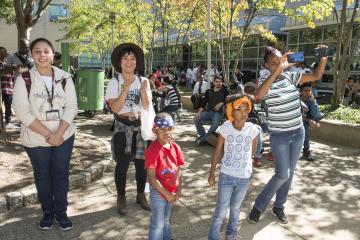 Members of the crowd, including to young children, watch the entertainment.