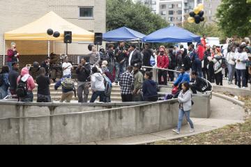 A crowd gathers to listen and dance to the DJ.