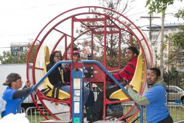 Four brave souls prepare to go for a spin in one of the "Tumbleweed," a spinning ride.