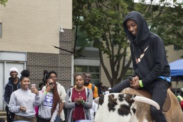 A rider smiles as he holds on to the Mechanical Bull ride.