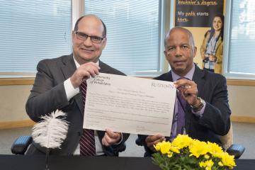 President Dr. Generals and President Hawkinson display the signed agreement..