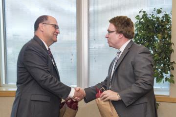 Vice President Sam Hirsch shakes hands with President Hawkinson.