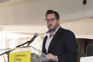 The president of Logan Square Neighborhood Association, Drew Murray, speaks to the audience.