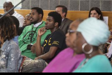 The audience listens to the President.