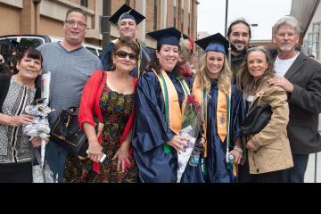 Three graduates celebrate with their families.