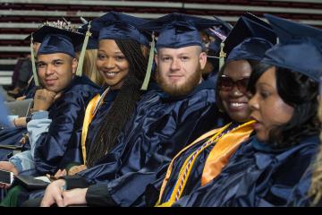 A group of graduates smiles for the camera.