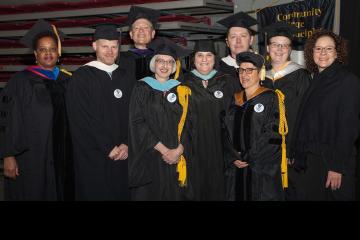 A group of faculty members smiles for the camera.