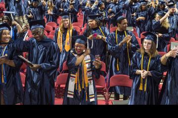 A crowd shot of graduates switching their tassels from the right to the left side.