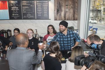 Eagles football player Chris Long serves Dr. Generals a coffee.