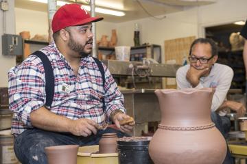 Roberto Lugo describes his technique as he spins a pot on the wheel