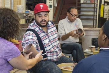 Roberto Lugo describes his technique as he spins a pot on the wheel