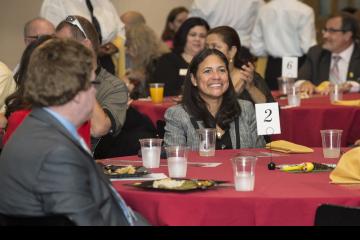 Former Board of Trustees President, Varsovia Fernandez smiles as Judy Gay acknowledges her contributions.