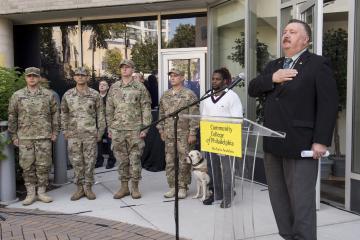 Stephen Bachovin, Veteran Programming Coordinator, stands with hand on heart for the National Anthem.