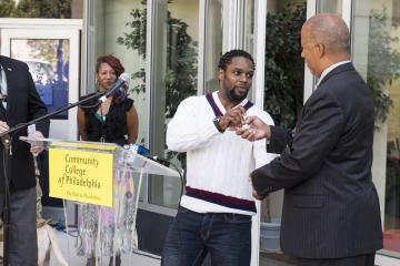 President Dr. Generals receives a challenge coin from veterans.