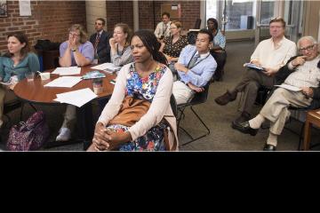 Faculty listen to a presentation.