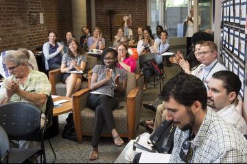 Faculty applaud a presentation.