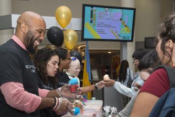 Welcome Week Staff serve students water ice.