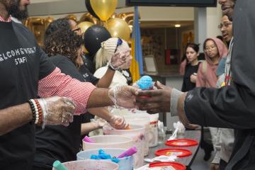 A staff member hands a student water ice.